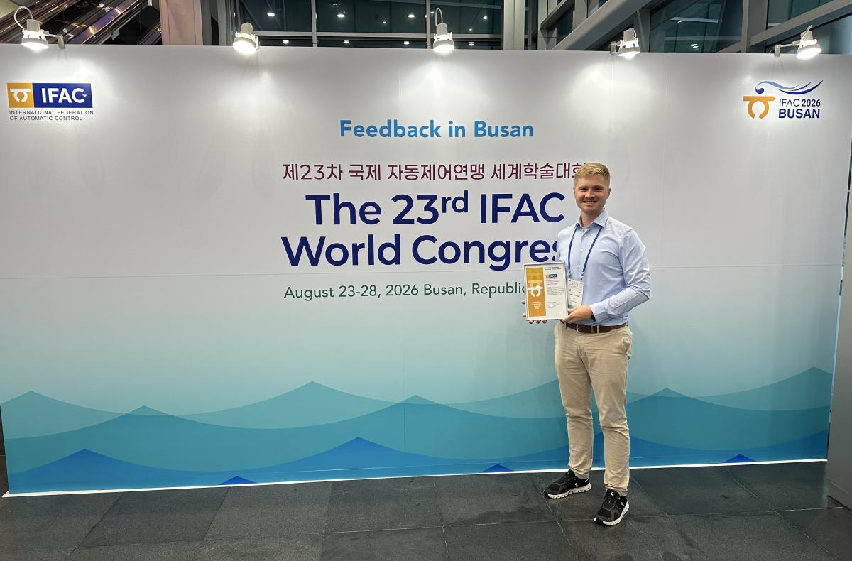 Lukas Ortmann holds his award next to the IFAC world congress entrance