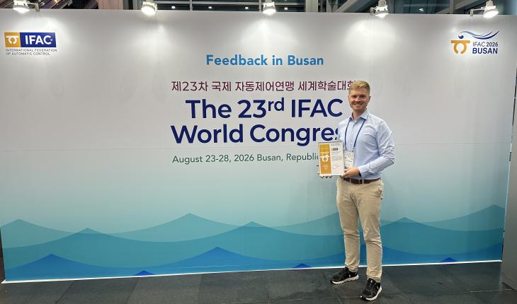 Lukas Ortmann holds his award next to the IFAC world congress entrance