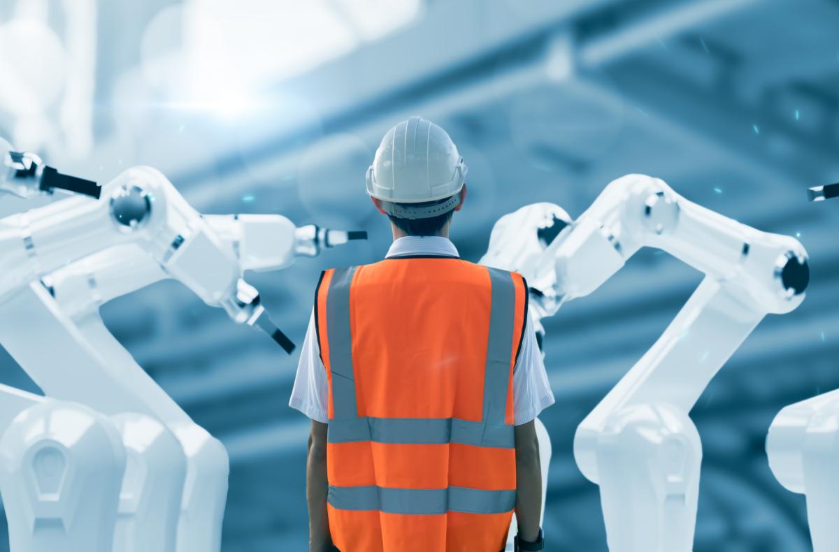 Man in safety gear surrounded by robotic arms