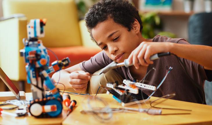 Young boy working on a robot