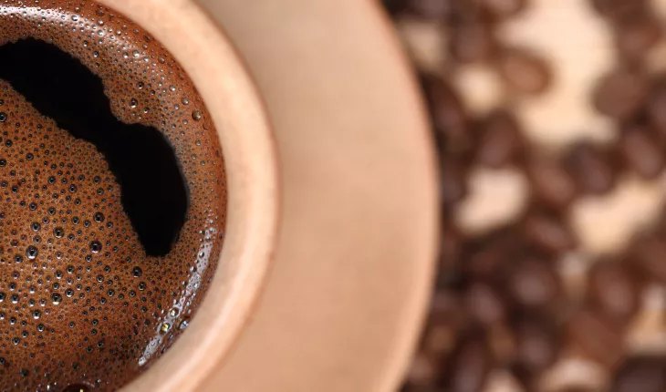 Coffee cup with bubbles swirling on the surface