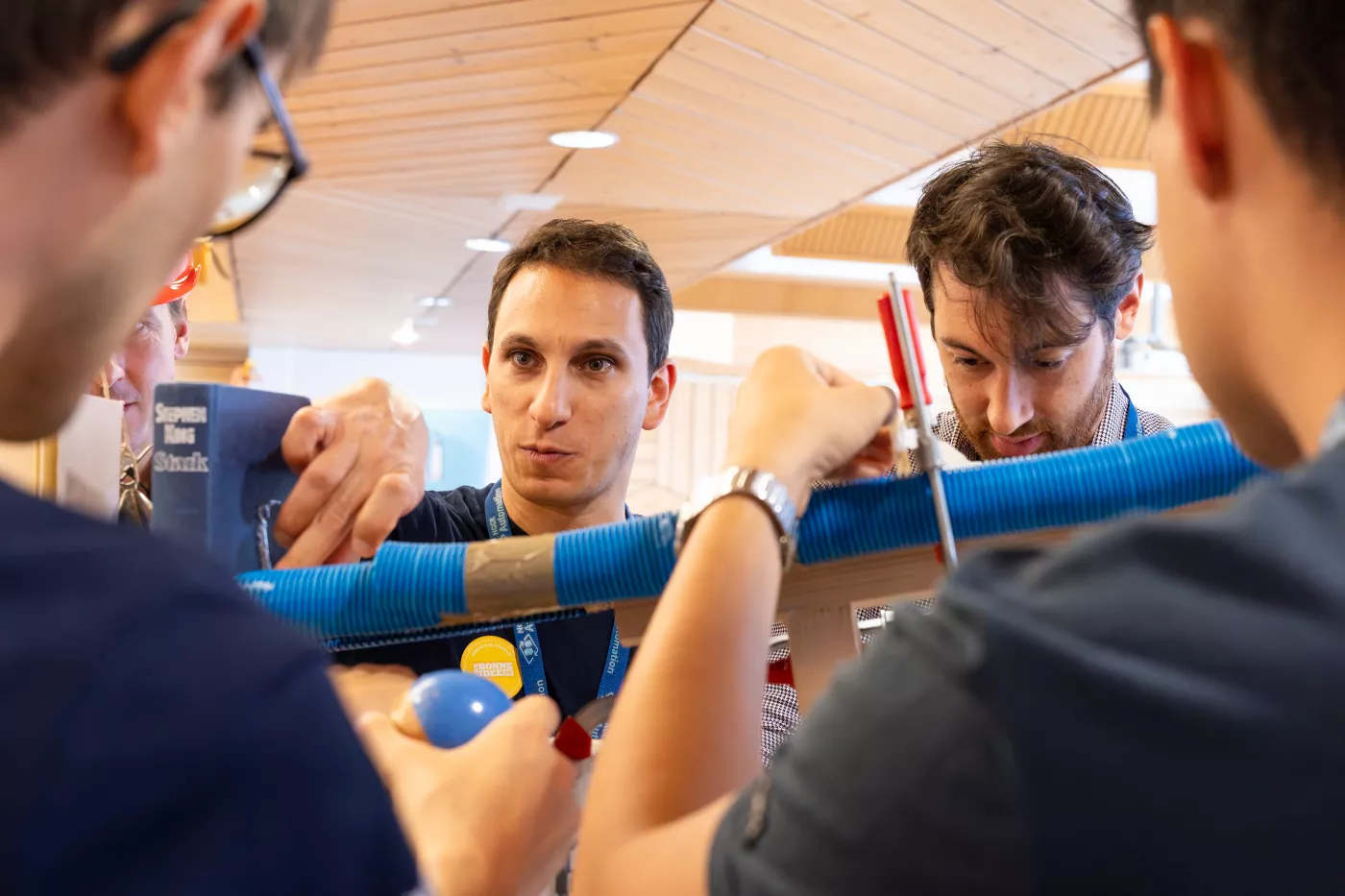 A man looks over a plastic pipe during a team building event