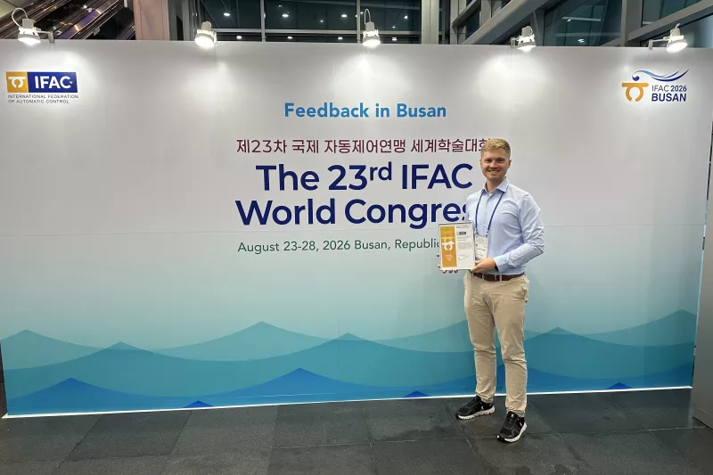 Lukas Ortmann holds his award next to the IFAC world congress entrance