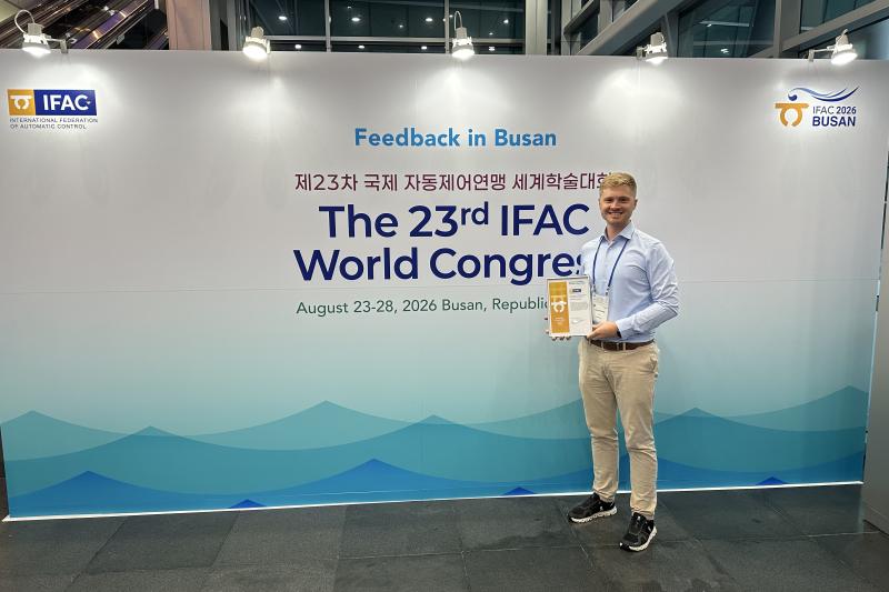 Lukas Ortmann holds his award next to the IFAC world congress entrance